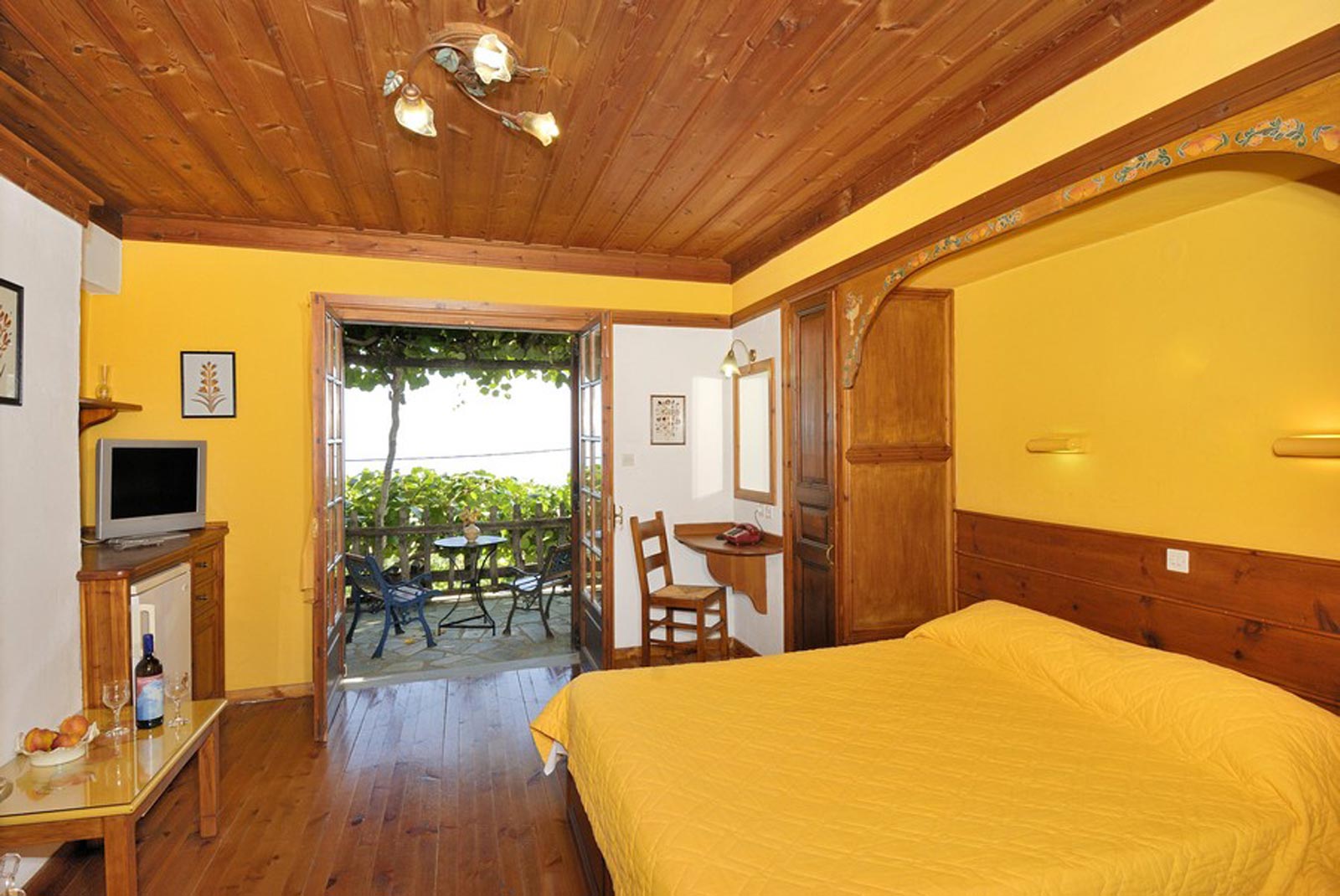 Classic double room, ochre walls, wooden ceiling, balcony door